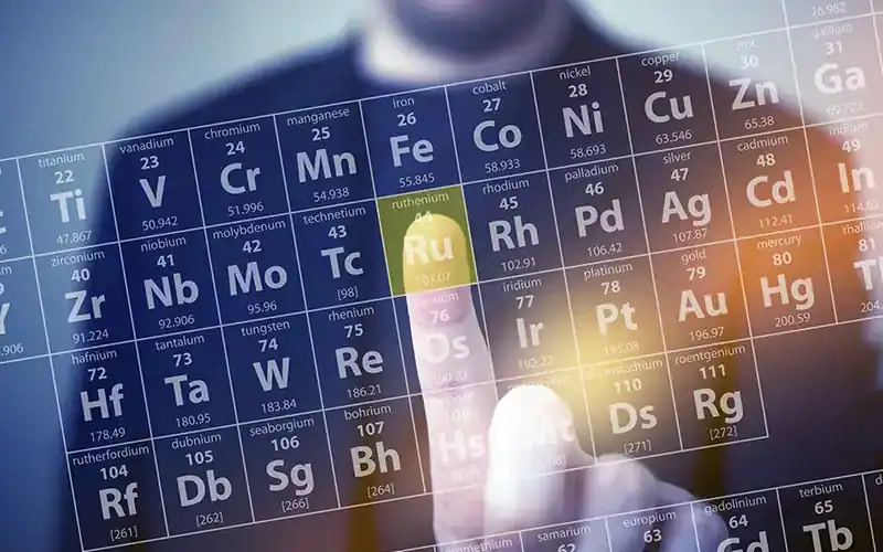 Persoon wijst naar het element Ruthenium in een interactieve weergave van het periodiek systeem der elementen.