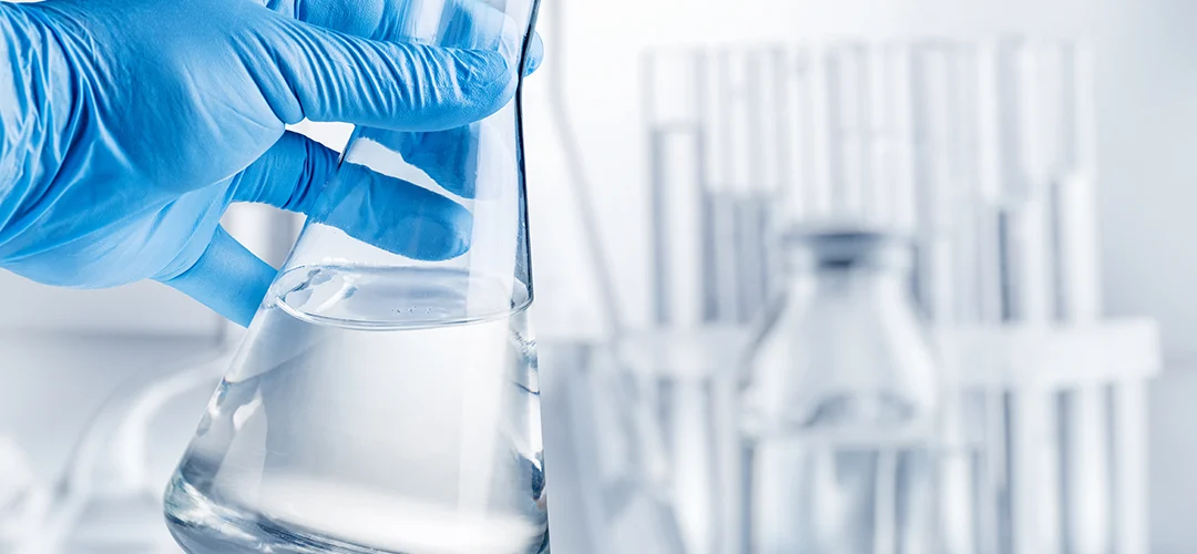 laboratoriumfles gevuld met heldere gedenatureerde alcohol in een labomgeving