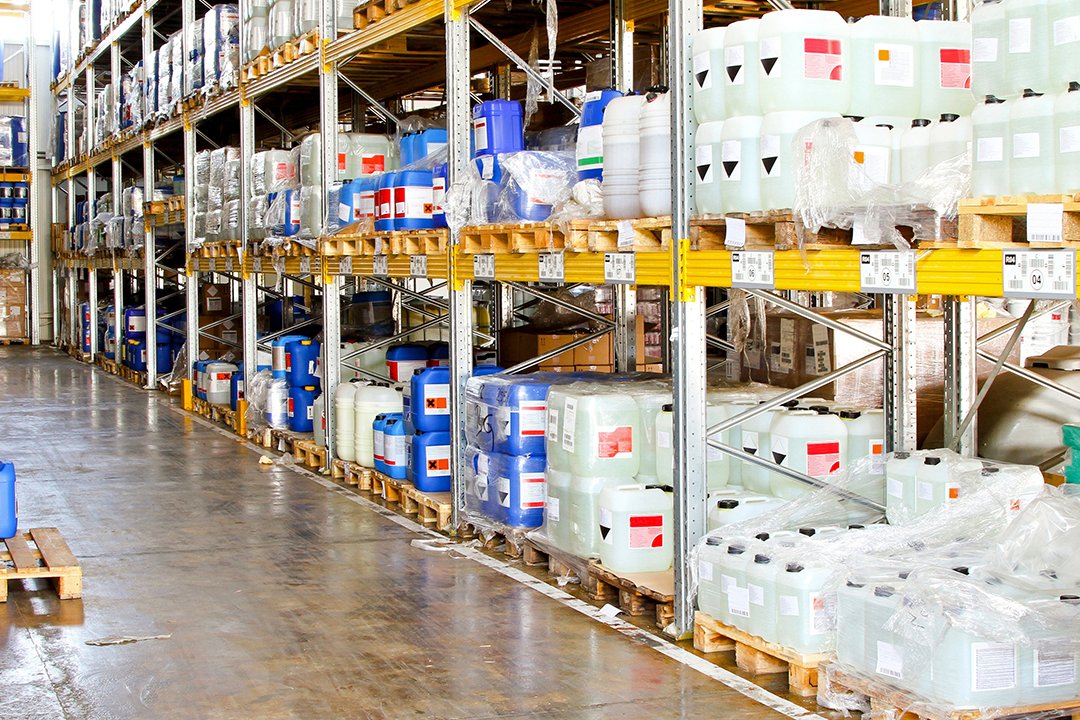 Warehouse with chemical products stored in labelled containers on pallets