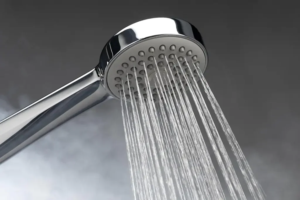 Photo of a shower head with steam in the background